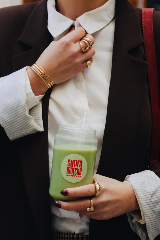 Verre de matcha latte froid tenu à la main — recette d'été