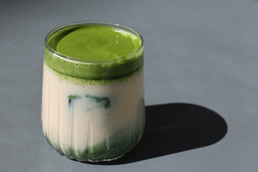 Matcha latte en couches dans un verre strié
