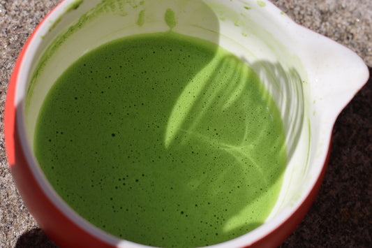 Surface de matcha fouetté dans un bol rouge